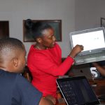 Susan Nzomo, a staff member at the Loyola Centre for Media and Communication, demonstrates how to easily generate spiritual content online using a laptop - LCMC | Media literacy education | Artificial Intelligence | Resilience | Formation | Media and communications training |Digital media literacy.- LCMC | Media literacy education | Artificial Intelligence | Resilience | Formation | Media and communications training |Digital media literacy