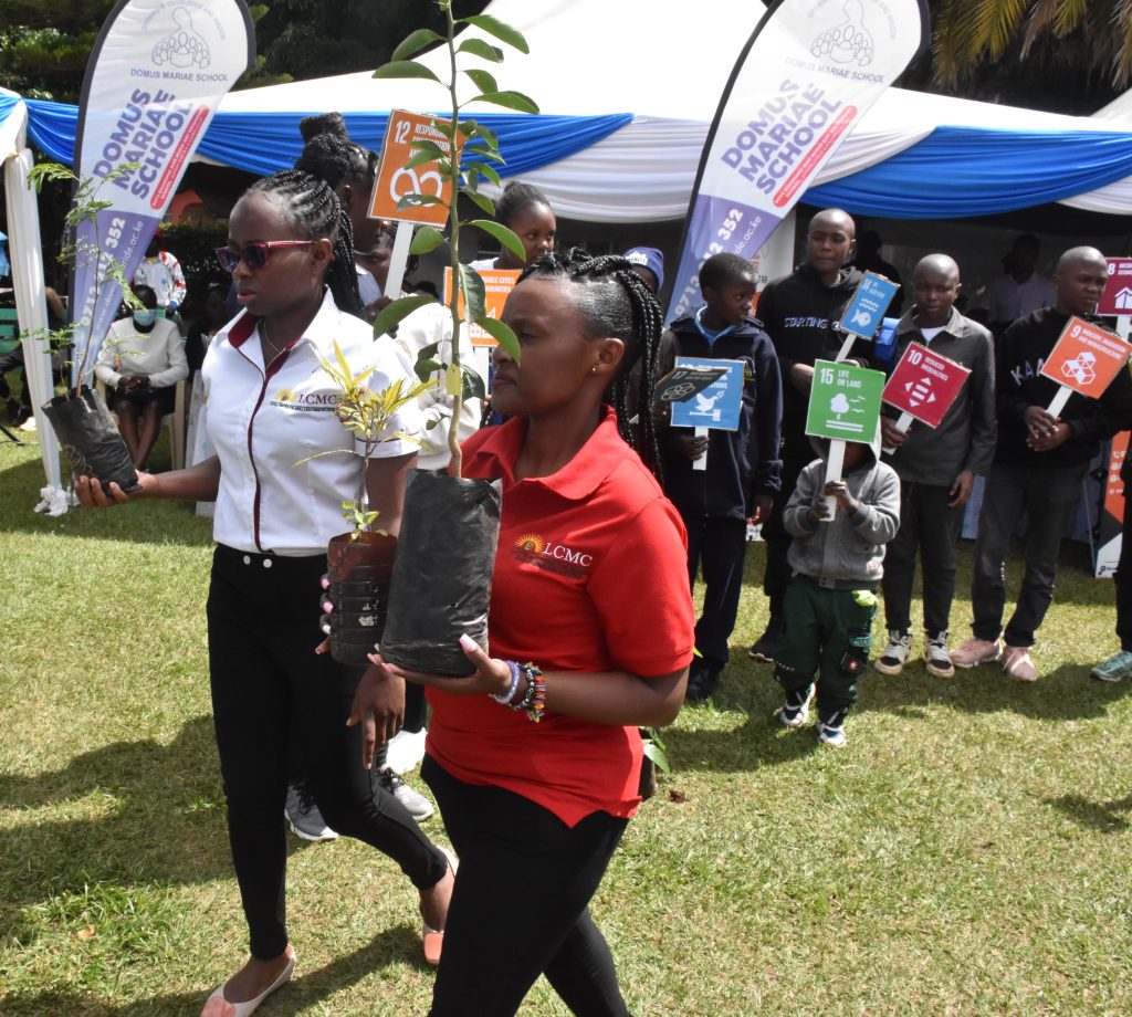Ms. Susan Nzomo (Left) and Ms. Teresia Muia (Right) from Loyola -centre for media and communications (LCMC), lead young attendees in a tree planting session, echoing the call of UN SDG 13 on climate action. - LCMC | Media literacy education | Artificial Intelligence | Resilience | Formation | Media and communications training |Digital media literacy